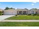 Charming home featuring a well-manicured lawn, two-car garage, and stylish exterior trim accents at 6111 Oxbow Bend Ln, Port Orange, FL 32128