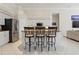 Kitchen featuring an island with three stools, granite counters, stainless appliances, and white cabinetry at 6111 Oxbow Bend Ln, Port Orange, FL 32128