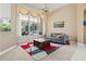 Living room features a comfortable grey couch, modern rug, and a large window with outdoor views at 6111 Oxbow Bend Ln, Port Orange, FL 32128