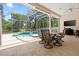Outdoor patio featuring a dining set, grill, and a view of the screened pool area at 6111 Oxbow Bend Ln, Port Orange, FL 32128