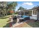 Outdoor patio features lounge seating, an umbrella, a grill, and is surrounded by green grass at 6247 Palomino Cir, Port Orange, FL 32127