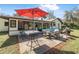 Backyard patio features outdoor dining and lounge seating, green grass and mature trees at 6247 Palomino Cir, Port Orange, FL 32127