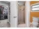 Updated bathroom showcasing shower, toilet, closet, tile floor and orange accent wall at 6247 Palomino Cir, Port Orange, FL 32127