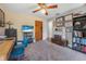 Bedroom with gray walls, ceiling fan, and wood flooring and an assortment of memorabilia on the walls at 6247 Palomino Cir, Port Orange, FL 32127