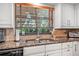 This kitchen features granite counters, a stainless steel sink, and natural light streaming through the window at 6247 Palomino Cir, Port Orange, FL 32127