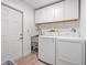 Laundry room features a stainless steel sink, washer, dryer, and white cabinets at 6247 Palomino Cir, Port Orange, FL 32127