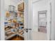 Walk-in pantry with metal shelving stocked with food and supplies next to the laundry room at 6247 Palomino Cir, Port Orange, FL 32127