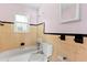Retro bathroom with yellow and black tile, featuring a combined tub and shower at 630 Florida Ave, Daytona Beach, FL 32117