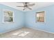 Light blue bedroom featuring a ceiling fan and two windows providing natural light at 630 Florida Ave, Daytona Beach, FL 32117