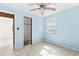 Light-filled bedroom with a ceiling fan and view to a closet with wood paneling at 630 Florida Ave, Daytona Beach, FL 32117