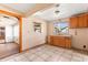 Functional kitchen featuring wood cabinets and tile flooring, leading to other rooms at 630 Florida Ave, Daytona Beach, FL 32117