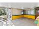 Enclosed patio featuring a concrete floor, access to the yard, and walls that are painted yellow and white at 630 Florida Ave, Daytona Beach, FL 32117