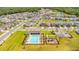 Wide aerial shot of neighborhood pool, playground, green spaces, and lush landscaping at 7068 Lanier Falls Rd, Deland, FL 32724