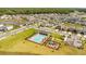 Aerial view of a neighborhood pool and playground with green spaces and neat landscaping at 7068 Lanier Falls Rd, Deland, FL 32724