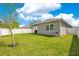 Spacious backyard featuring a well-kept lawn, and a white fence for privacy and security at 7068 Lanier Falls Rd, Deland, FL 32724