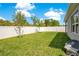 Private backyard with a lush green lawn, bordered by a white fence, perfect for outdoor activities at 7068 Lanier Falls Rd, Deland, FL 32724