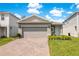 Charming home boasts a well-manicured lawn, brick paver driveway and two-car garage at 7068 Lanier Falls Rd, Deland, FL 32724
