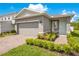 Exterior of a gray home with a well manicured yard and a two-car garage at 7068 Lanier Falls Rd, Deland, FL 32724