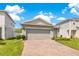 Exterior of a gray home with a well manicured yard and a brick paver driveway at 7068 Lanier Falls Rd, Deland, FL 32724