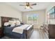 Spacious bedroom with wood-style floors, large bed, side tables, and a window view at 7068 Lanier Falls Rd, Deland, FL 32724