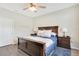 Cozy main bedroom with dark wood furniture, plush bedding, and a ceiling fan at 7068 Lanier Falls Rd, Deland, FL 32724