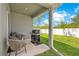 Cozy covered patio with grill and seating area overlooking a fenced backyard at 7068 Lanier Falls Rd, Deland, FL 32724