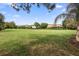 Expansive backyard featuring lush green grass, mature trees, and glimpses of neighboring homes at 716 Riviera Bella Dr, Debary, FL 32713
