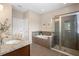 Bathroom featuring a soaking tub, glass-enclosed shower, and granite countertop vanity at 716 Riviera Bella Dr, Debary, FL 32713