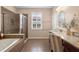 Bathroom featuring a soaking tub, glass-enclosed shower, and granite countertop vanity at 716 Riviera Bella Dr, Debary, FL 32713