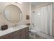 Bathroom with a round mirror, white vanity with gold fixtures and a shower-tub combination at 716 Riviera Bella Dr, Debary, FL 32713
