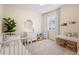 Bedroom with white crib, a dresser, a desk, area rug, and a bright window at 716 Riviera Bella Dr, Debary, FL 32713