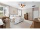 A relaxing bedroom with neutral tones, wood floors, a ceiling fan, and plantation shutters on the windows at 716 Riviera Bella Dr, Debary, FL 32713