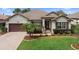 Charming single-story home featuring a well-manicured lawn, mature palm tree, and brick-paved driveway at 716 Riviera Bella Dr, Debary, FL 32713