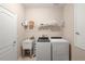 Functional laundry room with modern washer and dryer, utility sink, and storage shelves at 716 Riviera Bella Dr, Debary, FL 32713