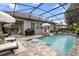 Screened-in pool area with patio furniture, grill, lounge chairs, umbrellas, and inviting blue water at 716 Riviera Bella Dr, Debary, FL 32713