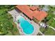 Aerial view of a community pool surrounded by lounge chairs, a covered patio and lush landscaping at 716 Riviera Bella Dr, Debary, FL 32713