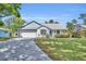 Charming single-story home with well-manicured lawn, blue and white color scheme, and inviting curb appeal at 717 S Ridgewood Ave, Ormond Beach, FL 32174