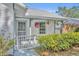 Close-up of front porch area with a white fence, hanging plants, and decorative trim at 717 S Ridgewood Ave, Ormond Beach, FL 32174