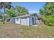 Detached garage with white siding and a roll-up door, set in a spacious backyard at 717 S Ridgewood Ave, Ormond Beach, FL 32174