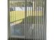 View through blinds of the backyard with a privacy fence and green grass at 736 S Stone St, Deland, FL 32720