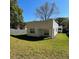 Back view of the house with a covered patio and spacious green backyard at 736 S Stone St, Deland, FL 32720