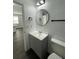 Updated bathroom featuring a modern vanity, round mirror, new fixtures, and a toilet at 736 S Stone St, Deland, FL 32720