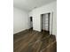 This bedroom features wood floors, neutral walls, and a closet with shelving for organization at 736 S Stone St, Deland, FL 32720