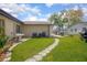 A well-kept backyard features a lush lawn and a stone walkway to enhance its charm at 792 Bennett Rd, South Daytona, FL 32119