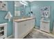Bright bathroom with double sink vanity, turquoise walls, decorative mirrors and lighting at 859 Oak Hollow Loop, Deland, FL 32724