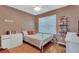 Bedroom with hardwood floors, white dresser, and a decorative white headboard on the bed at 859 Oak Hollow Loop, Deland, FL 32724