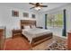 Cozy bedroom with hardwood floors, a ceiling fan, wooden furniture and lots of natural light at 859 Oak Hollow Loop, Deland, FL 32724