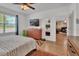 Bedroom with hardwood floors, large window, and dresser with wall-mounted television above at 859 Oak Hollow Loop, Deland, FL 32724