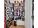 Walk-in closet with lots of clothing and shoes on display and storage bins on the upper shelves at 859 Oak Hollow Loop, Deland, FL 32724