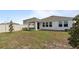 Backyard featuring a manicured lawn, privacy fence, covered patio and landscaped accents at 9392 Revere Ave, Leesburg, FL 34788